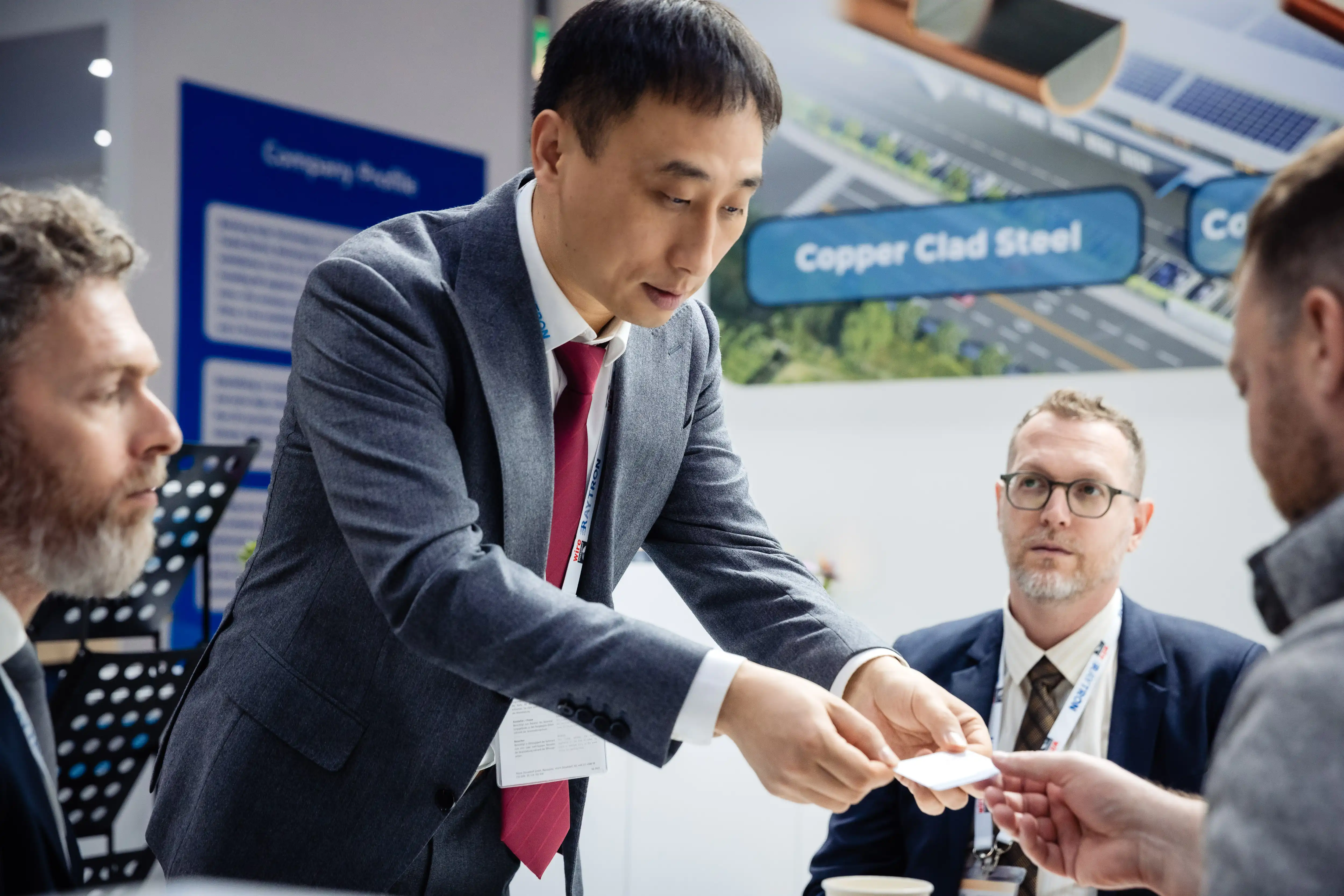 RAYTRON team in technical discussion with international visitors at the booth